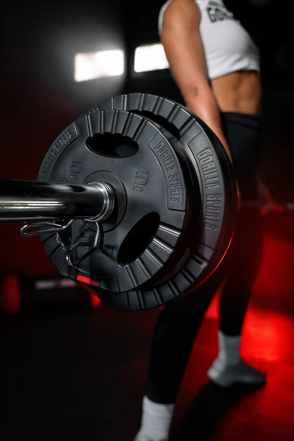 Sportivă cu halteră lungă și discuri pentru haltere